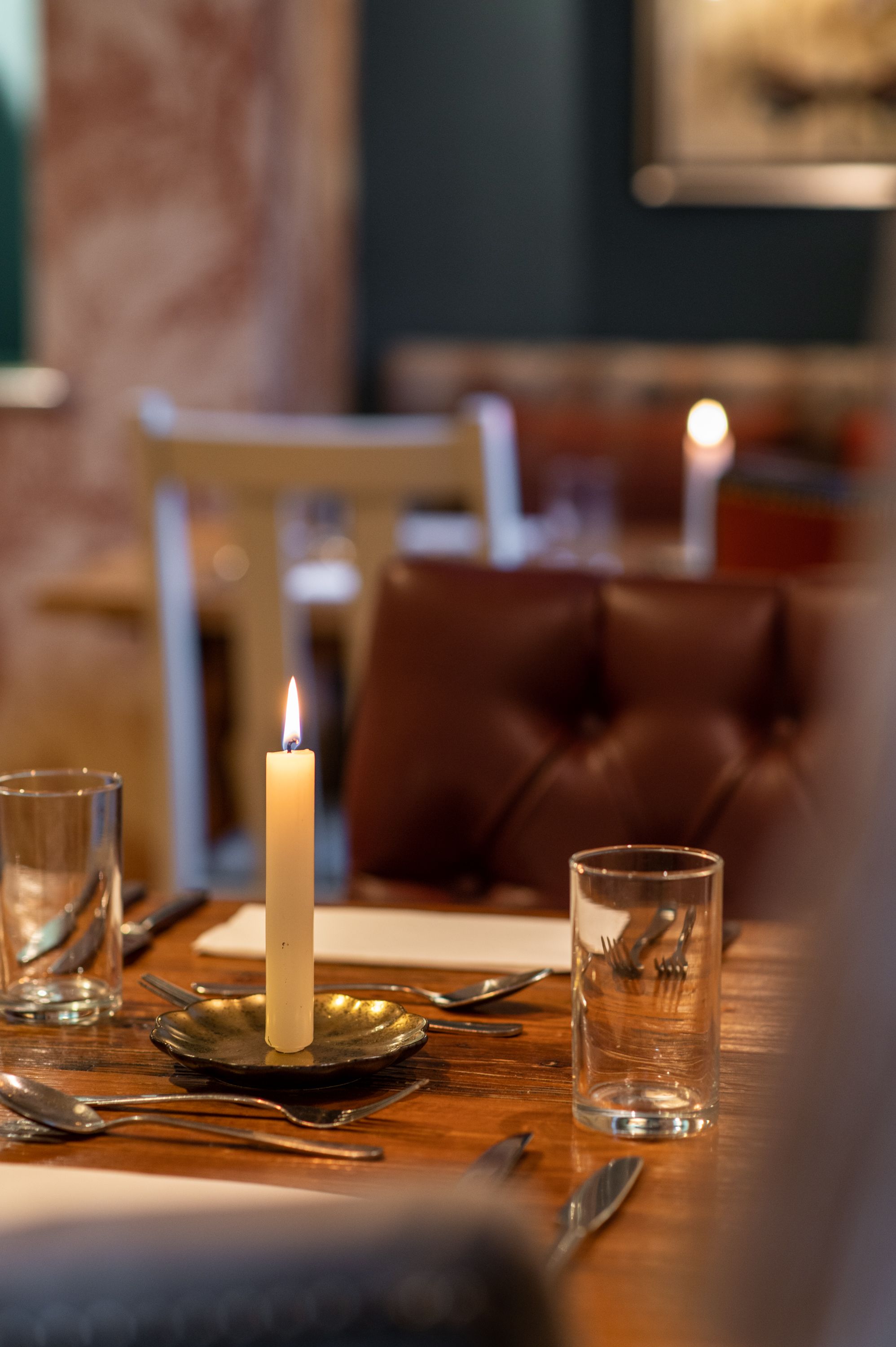 a table in the restaurant with a lit candlestick